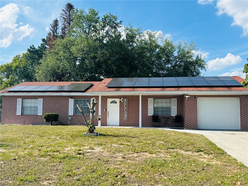 A single-story brick house with a solar panel roof and an attached garage — 640 E CUMMINGS STREET, LAKE ALFRED, FL