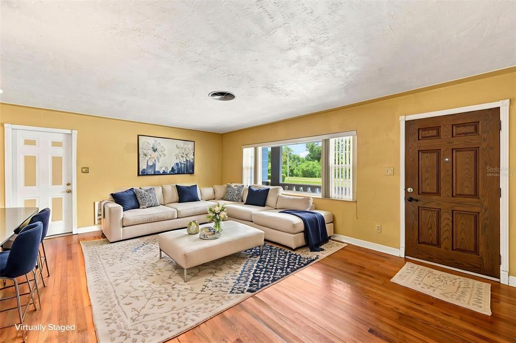 A living room with hardwood floors, a sectional sofa, and a front door — 4310 DR MARTIN LUTHER KING JR STREET S, ST PETERSBURG, FL
