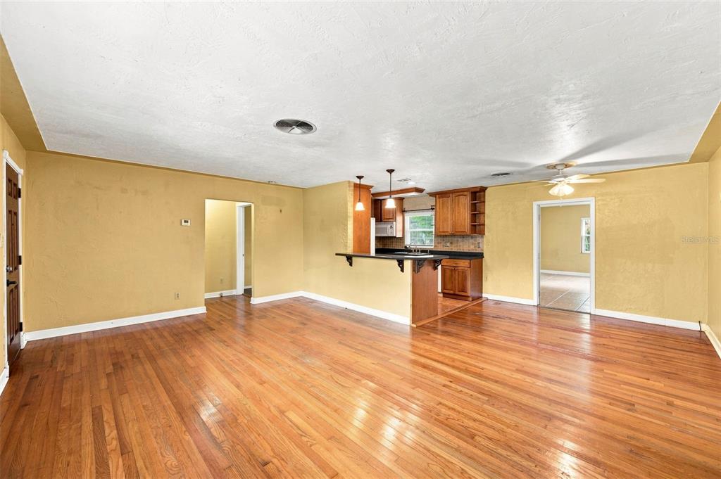 A living room with hardwood floors opens to a kitchen featuring wood cabinets and counters — 4310 DR MARTIN LUTHER KING JR STREET S, ST PETERSBURG, FL