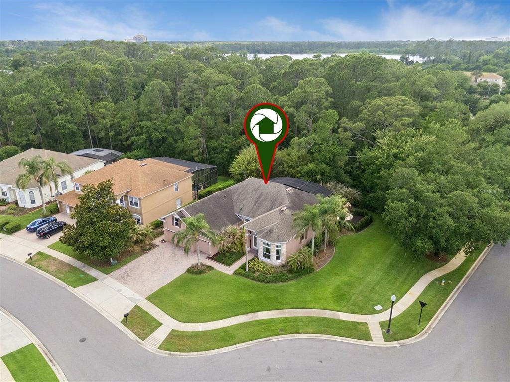 An aerial view shows a single-story house with a pool cage on a corner lot — 10490 WISCANE AVENUE, ORLANDO, FL