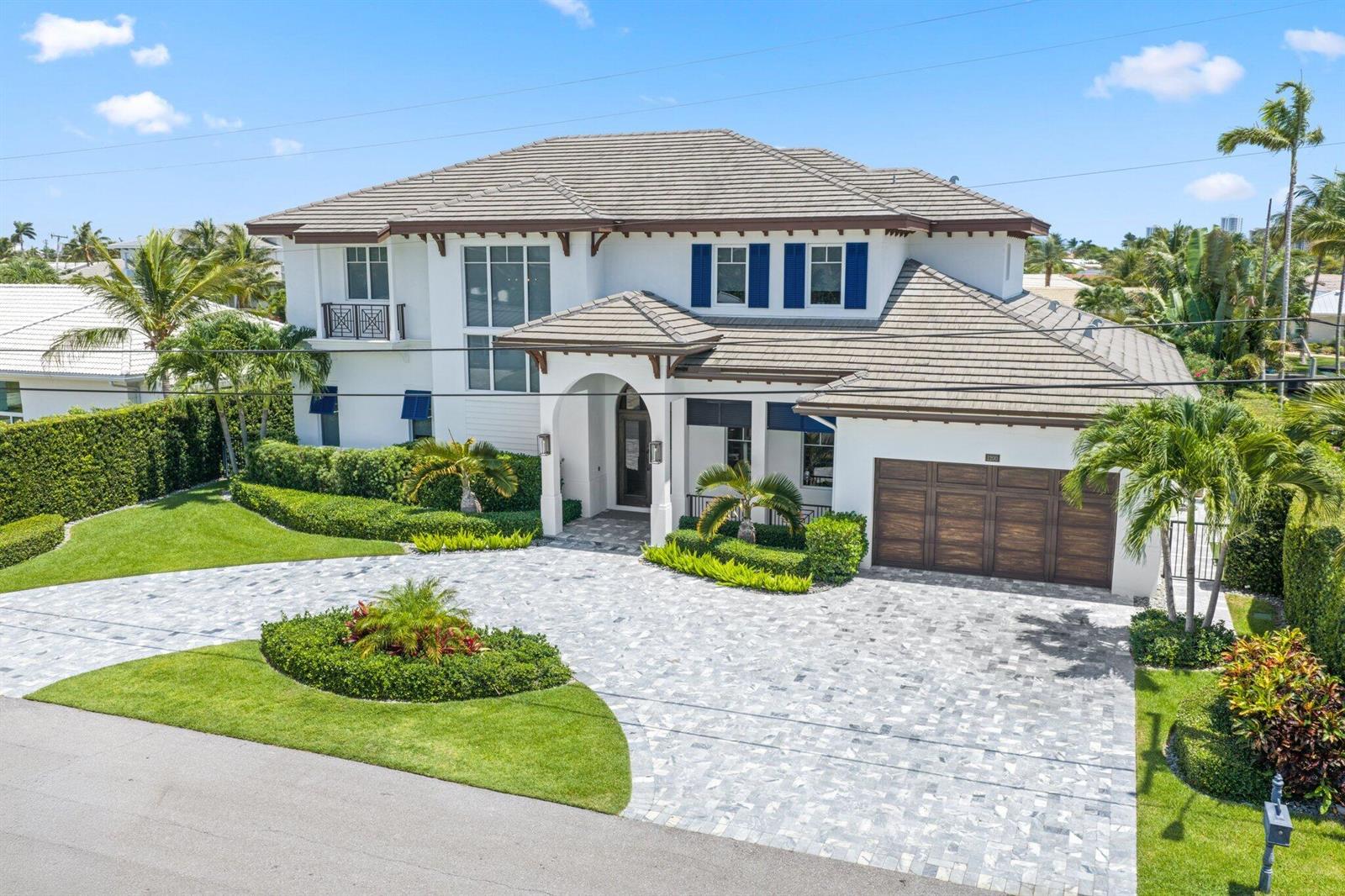 A two-story white house with a tiled roof, wooden garage doors, and a paved driveway — 1200 Bimini Lane, Singer Island FL 33404, SINGER ISLAND, FL