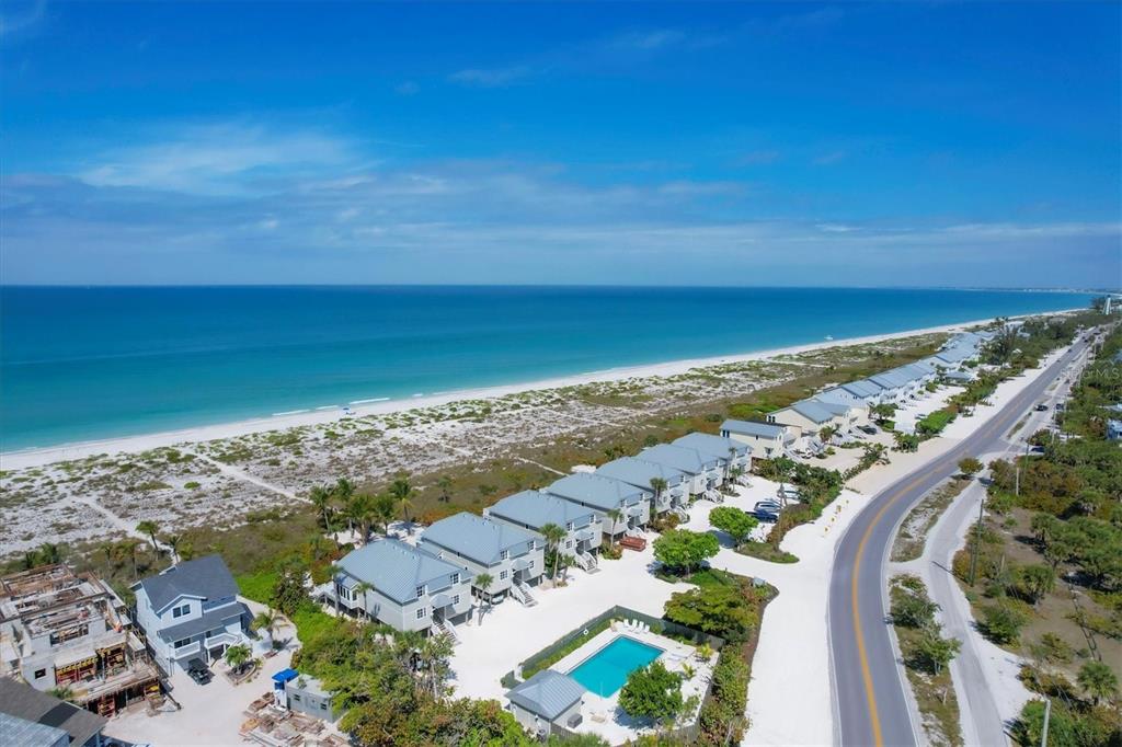 An aerial view shows a row of coastal houses near a beach and a road — 480 GULF BOULEVARD UNIT 6, BOCA GRANDE, FL