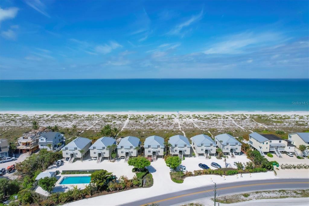An aerial view shows a row of beach houses near the ocean with a pool — 480 GULF BOULEVARD UNIT 6, BOCA GRANDE, FL
