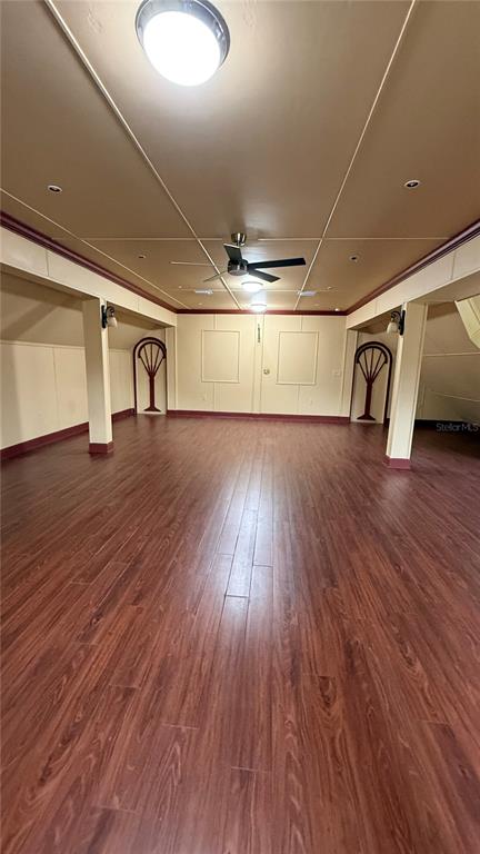 A spacious room features wood-look flooring, a ceiling fan, and decorative wall panels — 1965 SW LITTLE ROAD UNIT D, LAKE CITY, FL