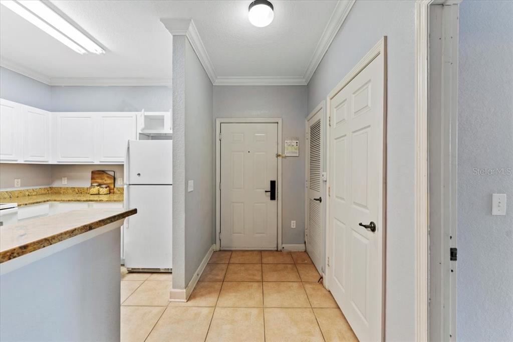 A tiled entryway leads to a white front door next to a kitchen area — 1361 TUSCAN TERRACE UNIT 7301, DAVENPORT, FL