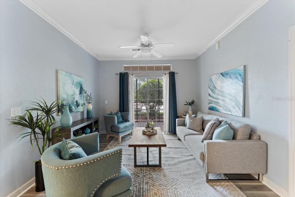A living room features a grey sofa, two teal armchairs, and a sliding glass door — 1361 TUSCAN TERRACE UNIT 7301, DAVENPORT, FL