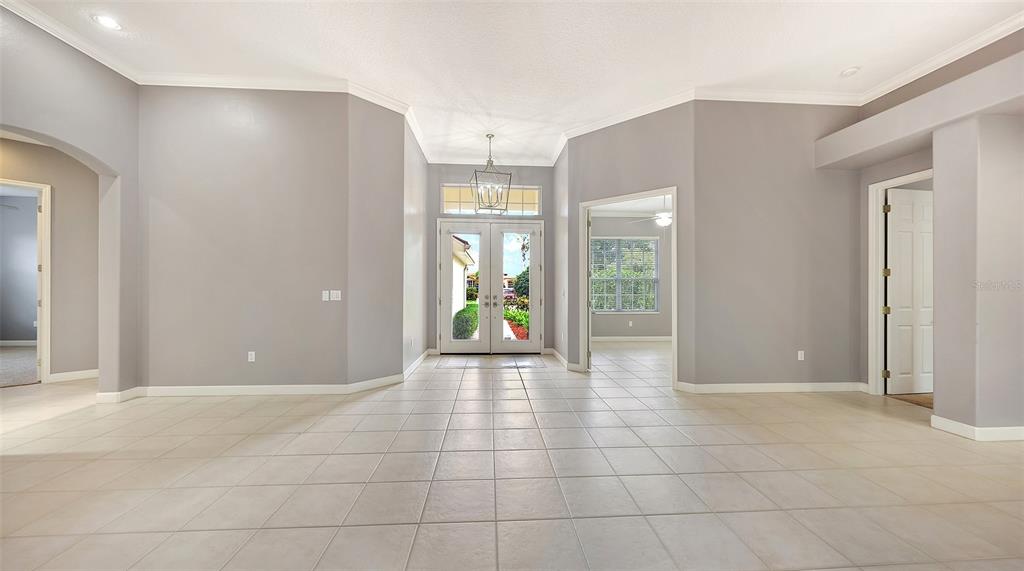 A single-story house with a tiled roof, three-car garage, and a paved driveway — 6209 CYPRESS BEND COURT, BRADENTON, FL