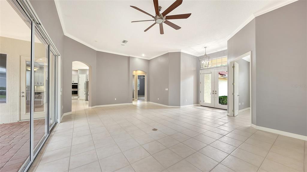 A paved walkway leads to the red double front doors of a beige stucco house — 6209 CYPRESS BEND COURT, BRADENTON, FL