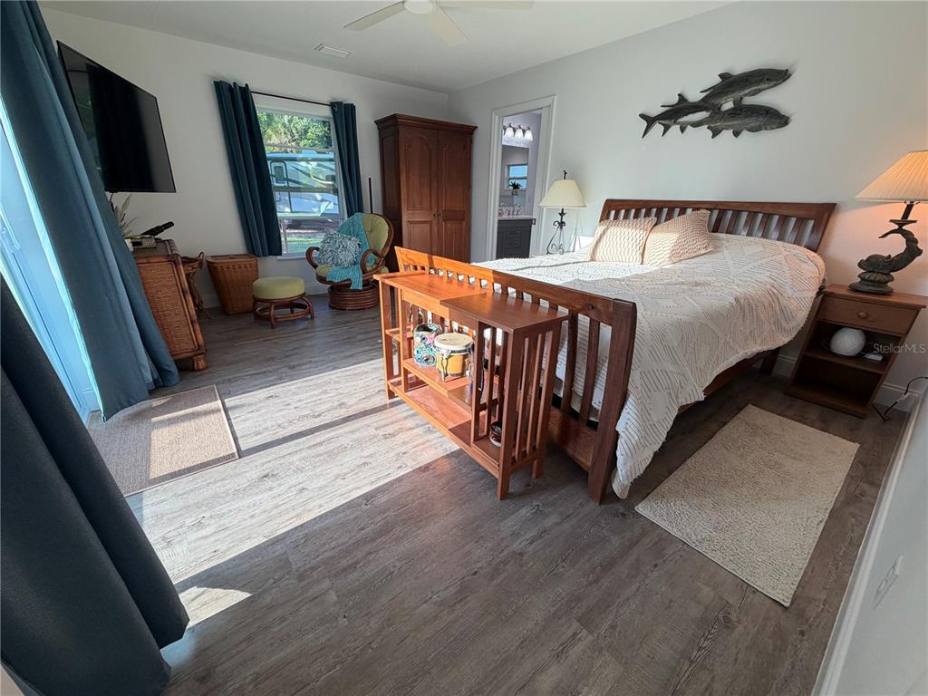 A bedroom features a wooden bed frame, a console table, and wood-look flooring — 4620 7TH AVENUE W, BRADENTON, FL