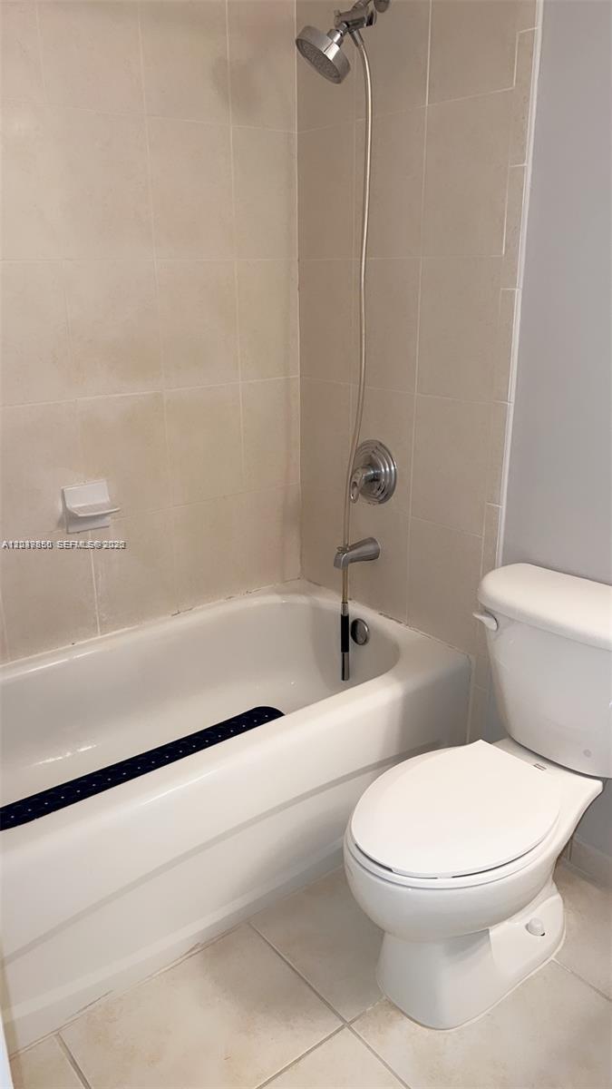 A bathroom features a white bathtub with a handheld showerhead and a white toilet — 7350 NW 114th Ave # 103, Doral FL 33178, DORAL, FL