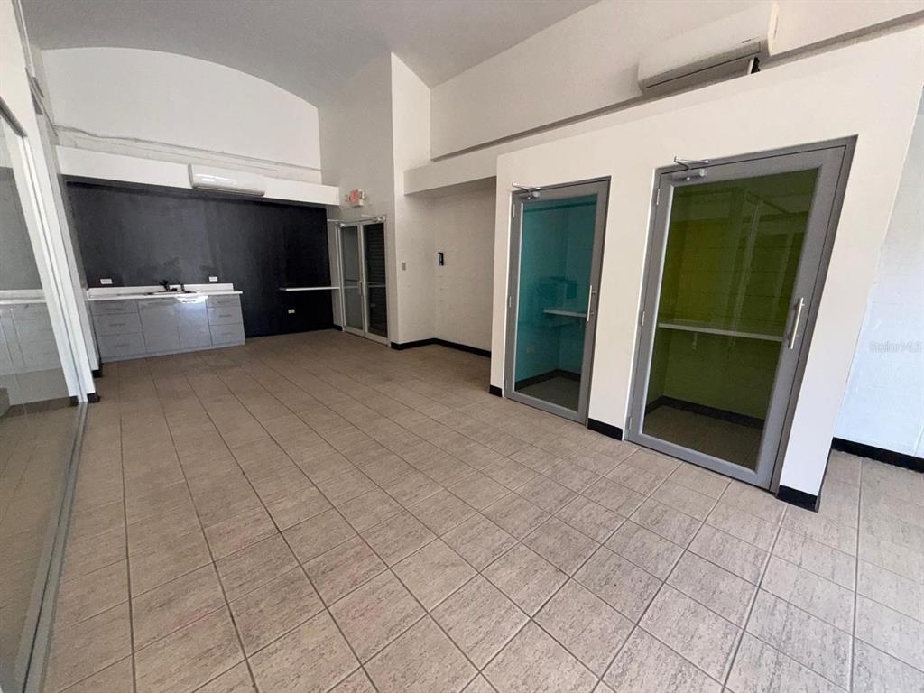 An office interior features tiled floors, a kitchenette with dark walls, and two glass-enclosed booths — 2822 AVE LAS AMÉRICAS, PONCE, PR