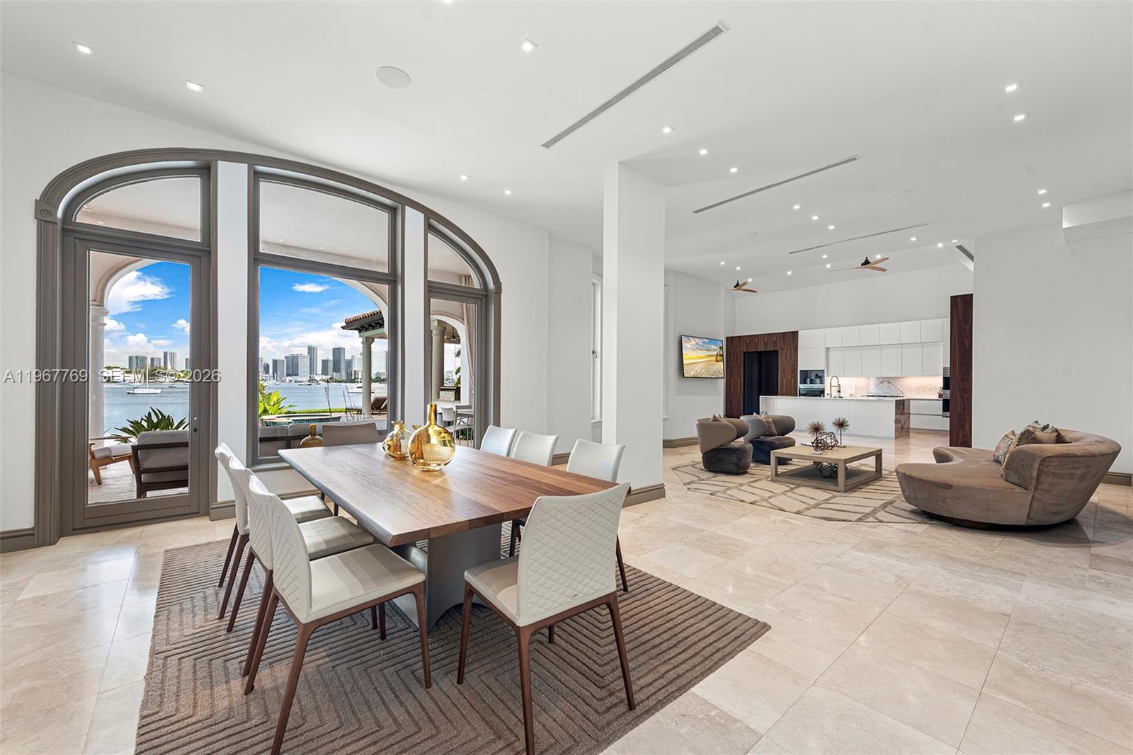 This open-concept living and dining area features tile floors, modern furniture, and floor-to-ceiling windows — 432 S Hibiscus Dr, Miami Beach FL 33139, MIAMI BEACH, FL
