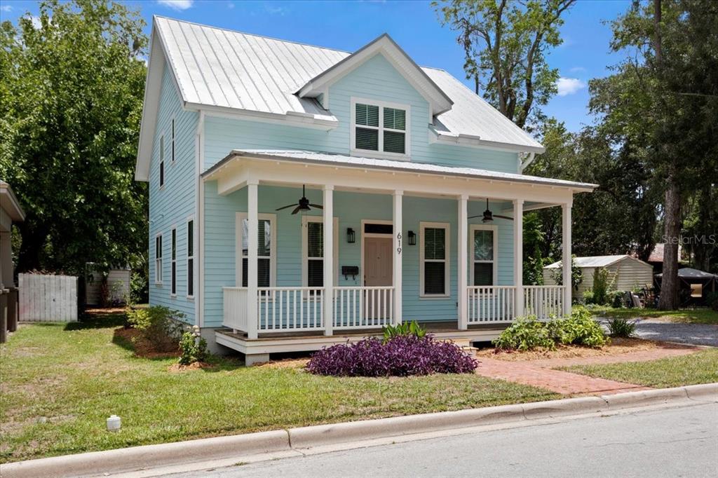 A light blue two-story house with a metal roof and a covered front porch — 619 NW 3RD STREET, GAINESVILLE, FL