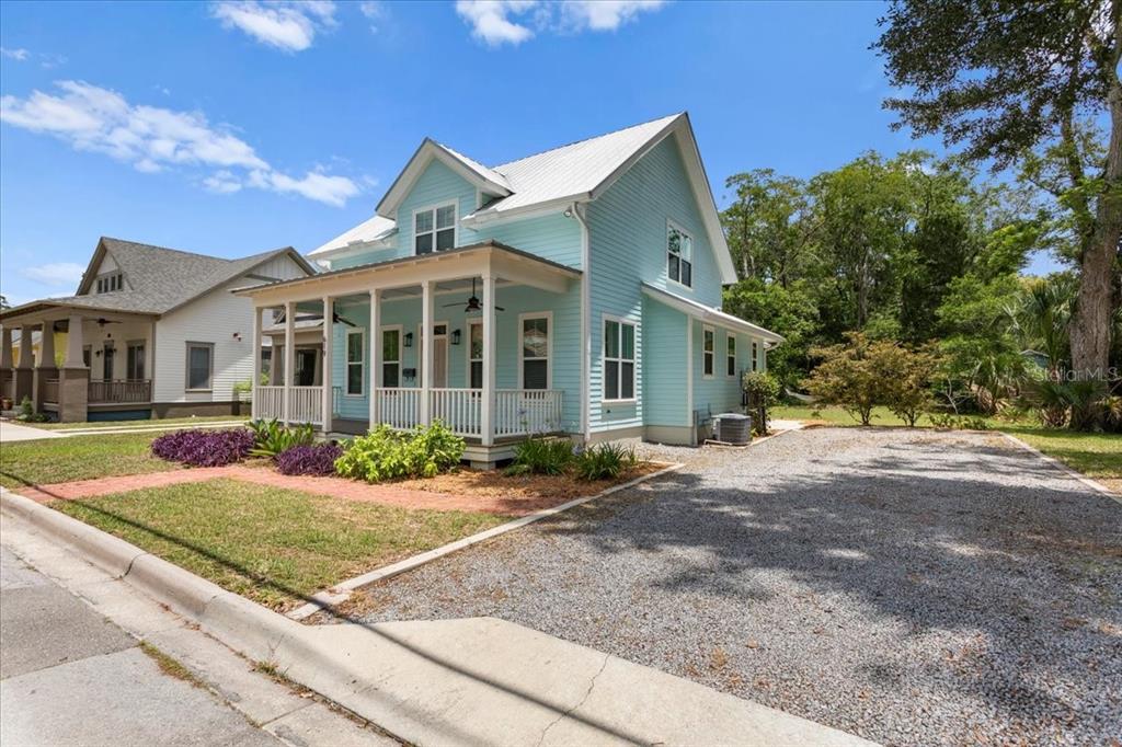 A light blue two-story house with a white metal roof and a front porch — 619 NW 3RD STREET, GAINESVILLE, FL