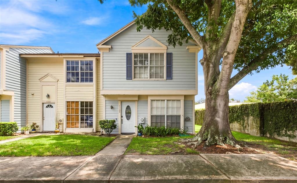 A two-story townhouse with light blue siding, a white front door, and a large tree — 1760 MILL RUN CIRCLE, TAMPA, FL