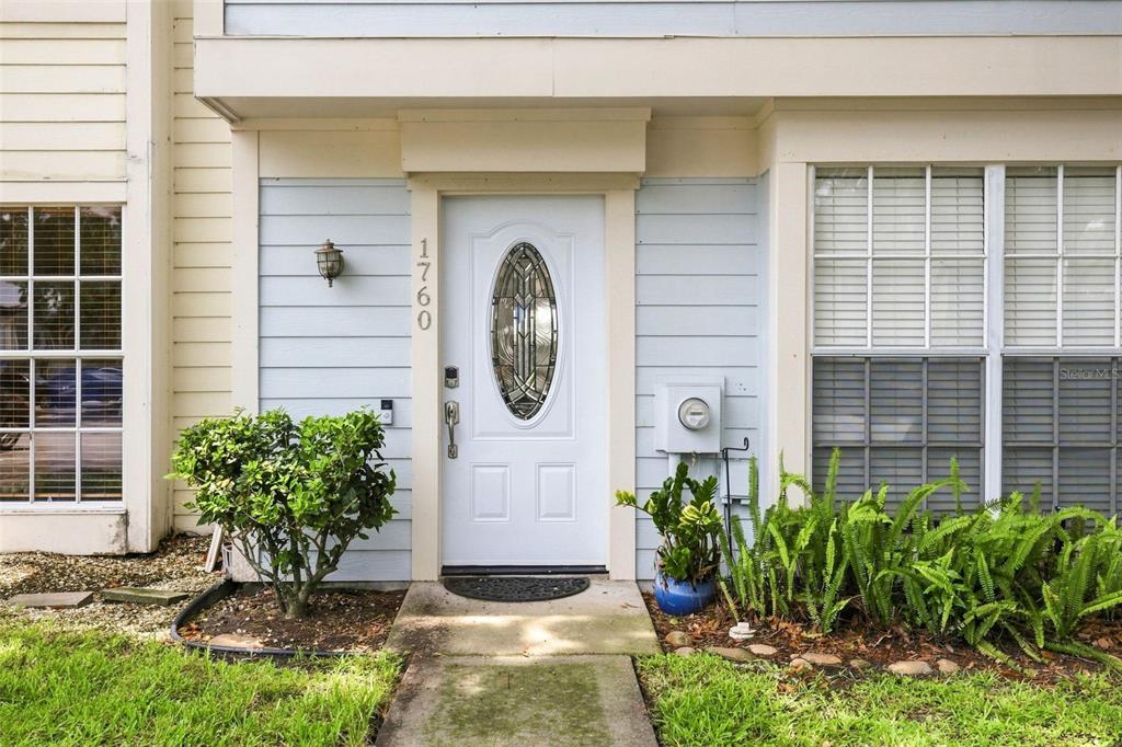 The exterior of a home features a white front door with a decorative oval window — 1760 MILL RUN CIRCLE, TAMPA, FL