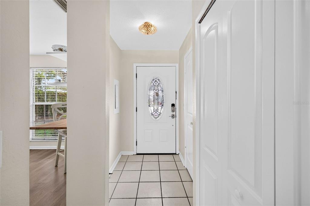 A tiled entryway features a white front door with a decorative oval glass insert — 1760 MILL RUN CIRCLE, TAMPA, FL