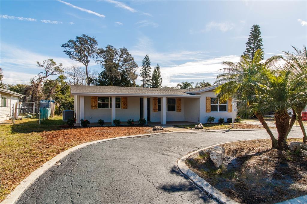 A single-story house with a curved driveway and wooden shutters on the windows — 7122 ASTOR DRIVE, NEW PORT RICHEY, FL