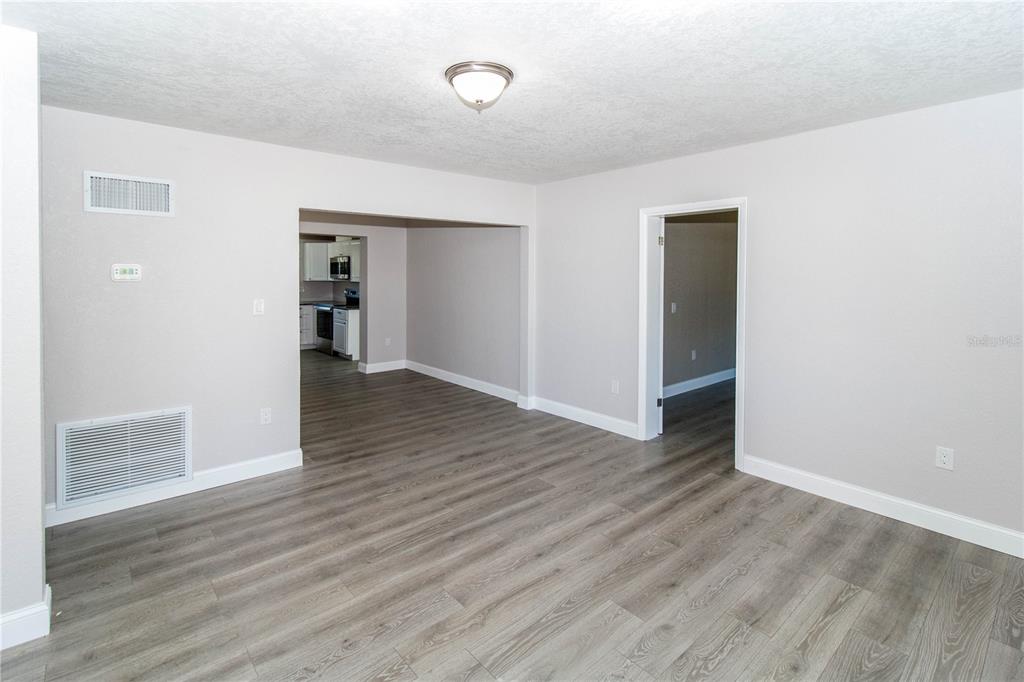 An interior view of a living area with gray wood-look flooring and white walls — 7122 ASTOR DRIVE, NEW PORT RICHEY, FL
