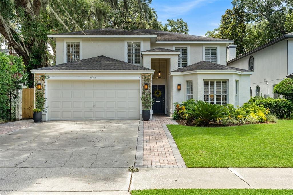 A two-story house with a beige stucco exterior, a two-car garage, and a brick walkway — 533 W YALE STREET, ORLANDO, FL