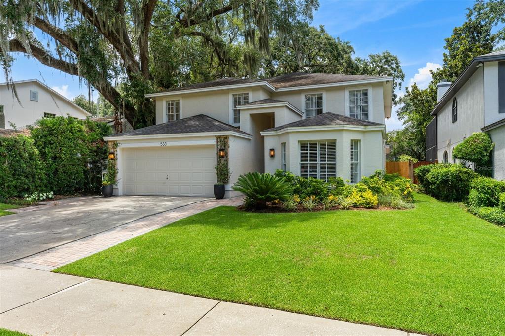 A two-story house with a beige exterior, a two-car garage, and a landscaped front yard — 533 W YALE STREET, ORLANDO, FL