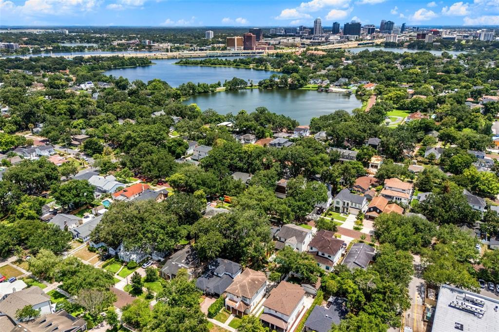 An aerial view shows a residential neighborhood with many trees near a large lake — 533 W YALE STREET, ORLANDO, FL