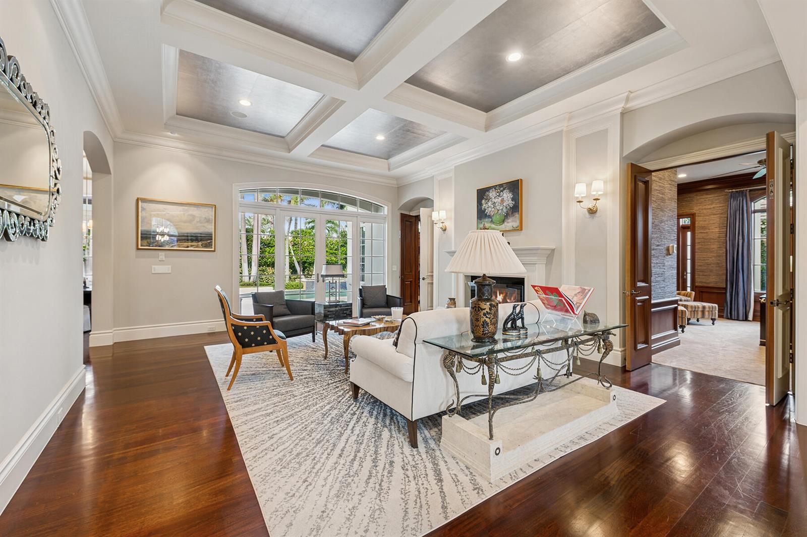 A living room features a coffered ceiling, fireplace, dark wood floors, and glass-paned doors — 293 Sabal Palm Terrace, Boca Raton FL 33432, BOCA RATON, FL