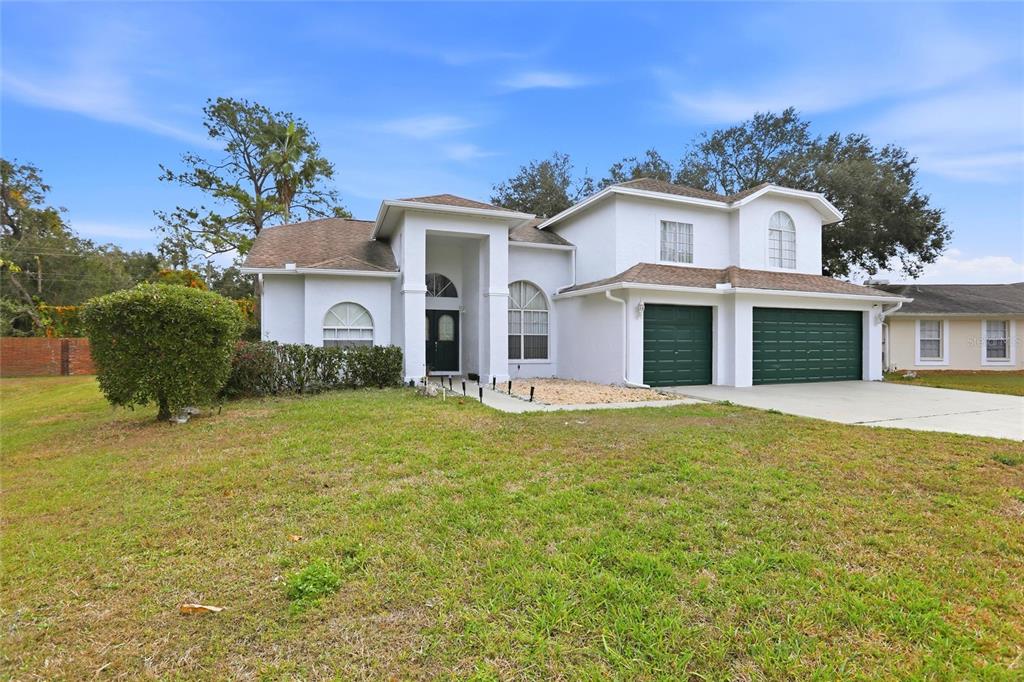 A two-story white house with a green two-car garage and a front yard — 10402 ASHLEY OAKS DRIVE, RIVERVIEW, FL