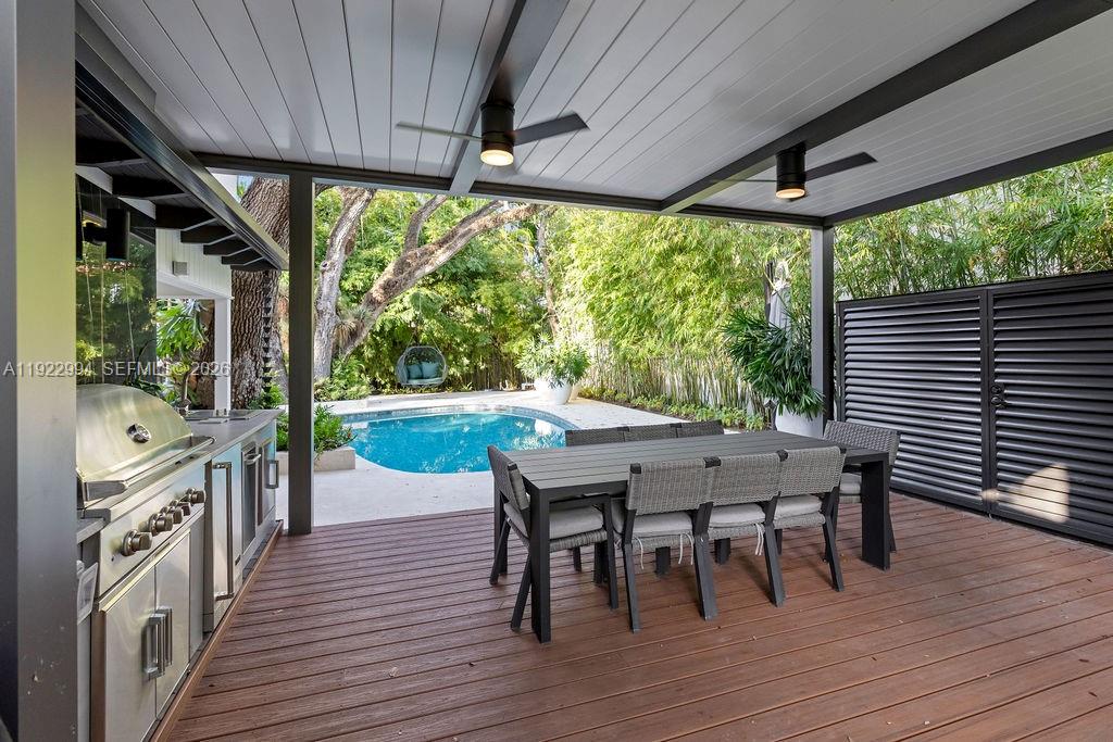 A covered outdoor patio features a stainless steel grill, dining table, and swimming pool — 4095 Battersea Rd, Miami FL 33133, MIAMI, FL