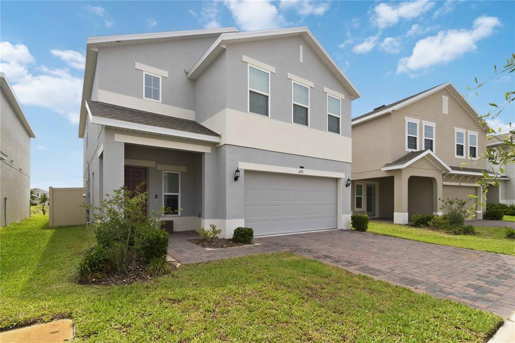 A two-story gray house with a two-car garage and a paved driveway — 1275 ISLAND SLOUGH LANE, DAVENPORT, FL