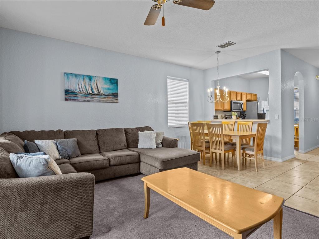A living room with a sectional sofa and coffee table opens to a dining area — 408 MIRAMAR AVENUE, DAVENPORT, FL