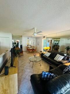 A living room features tile floors, a ceiling fan, and a black leather sofa — 505 Gardens Drive # 204, Pompano Beach FL 33069, POMPANO BEACH, FL