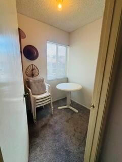 A small room with gray carpet, a white pedestal table, and a stack of chairs — 505 Gardens Drive # 204, Pompano Beach FL 33069, POMPANO BEACH, FL