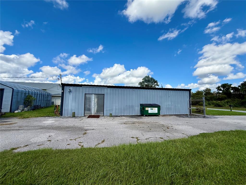 A metal-sided commercial building sits on a paved lot with a green dumpster nearby — 530 W BRANNEN ROAD, LAKELAND, FL