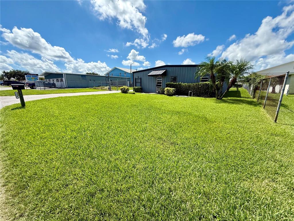 A low-slung metal building sits on a large, grassy lot under a bright blue sky — 530 W BRANNEN ROAD, LAKELAND, FL
