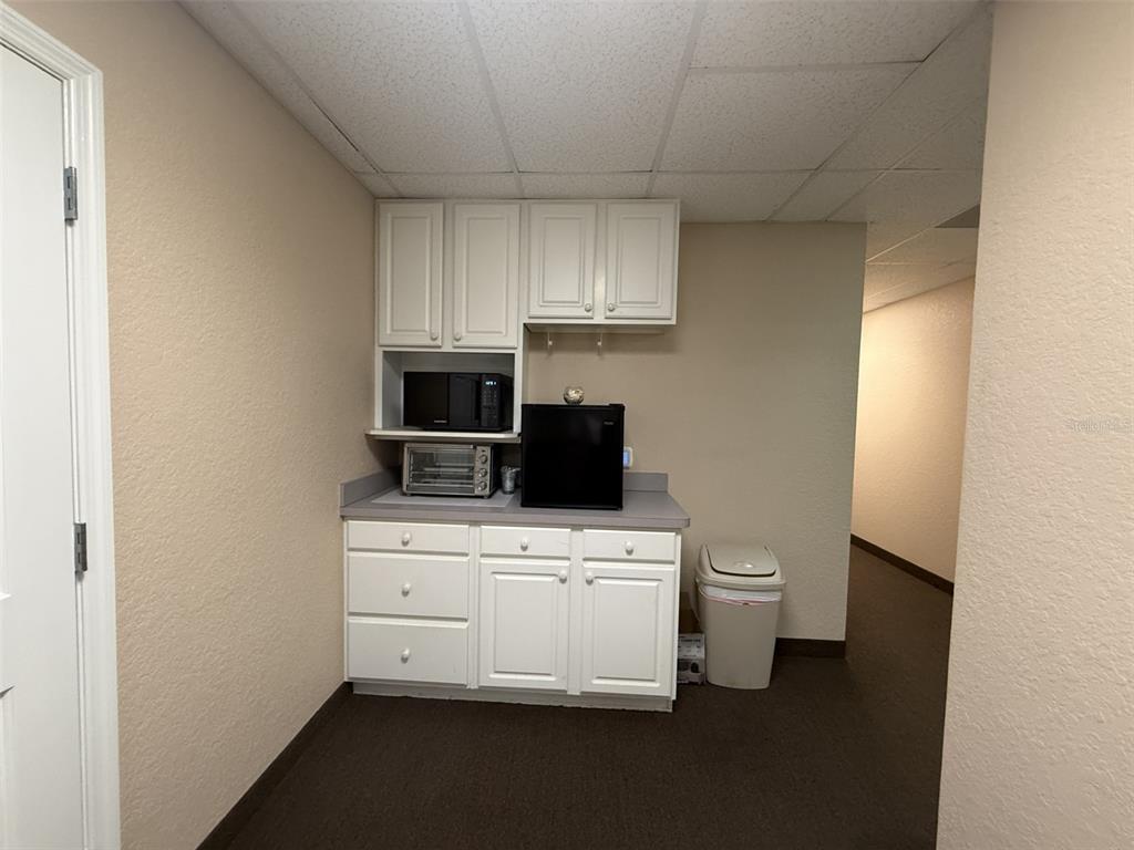 A small kitchenette features white cabinets, a microwave, a toaster oven, and a mini-fridge — 2609 SW 33RD STREET UNIT 101-4, OCALA, FL
