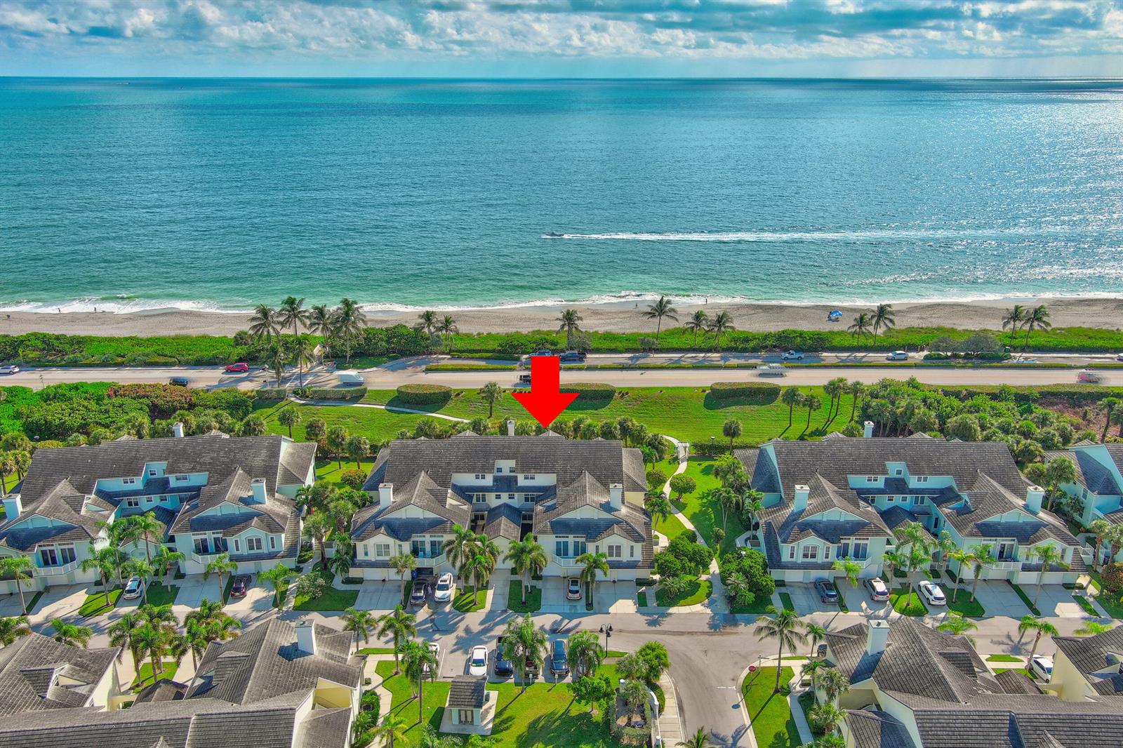 An aerial view of a coastal residential complex featuring townhouses, palm trees, and a beach — 406 Mainsail Circle, Jupiter FL 33477, JUPITER, FL