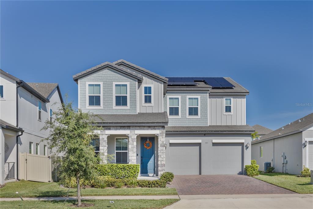 A two-story suburban house with a gray exterior, stone accents, and a two-car garage — 5150 CITRUS LEAF BOULEVARD, WINTER GARDEN, FL