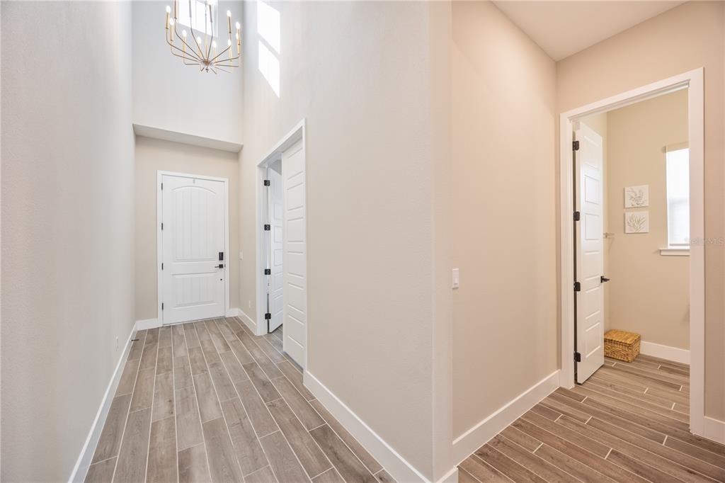 An entryway with wood-look tile flooring, a high ceiling, and a modern chandelier — 5150 CITRUS LEAF BOULEVARD, WINTER GARDEN, FL