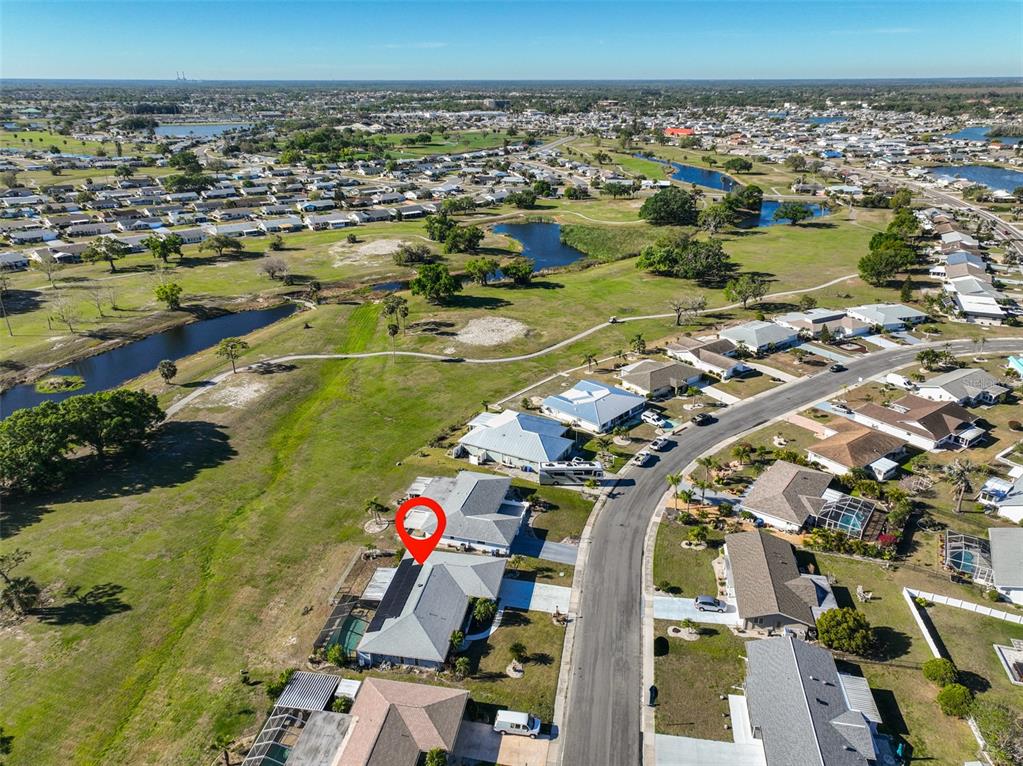 An aerial view shows a residential neighborhood with a red pin marking a specific house — 672 ALLEGHENY DRIVE, SUN CITY CENTER, FL