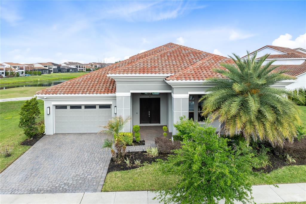A single-story house with a gray exterior, tile roof, and a paved driveway — 13370 ALDERLEY DRIVE, ORLANDO, FL