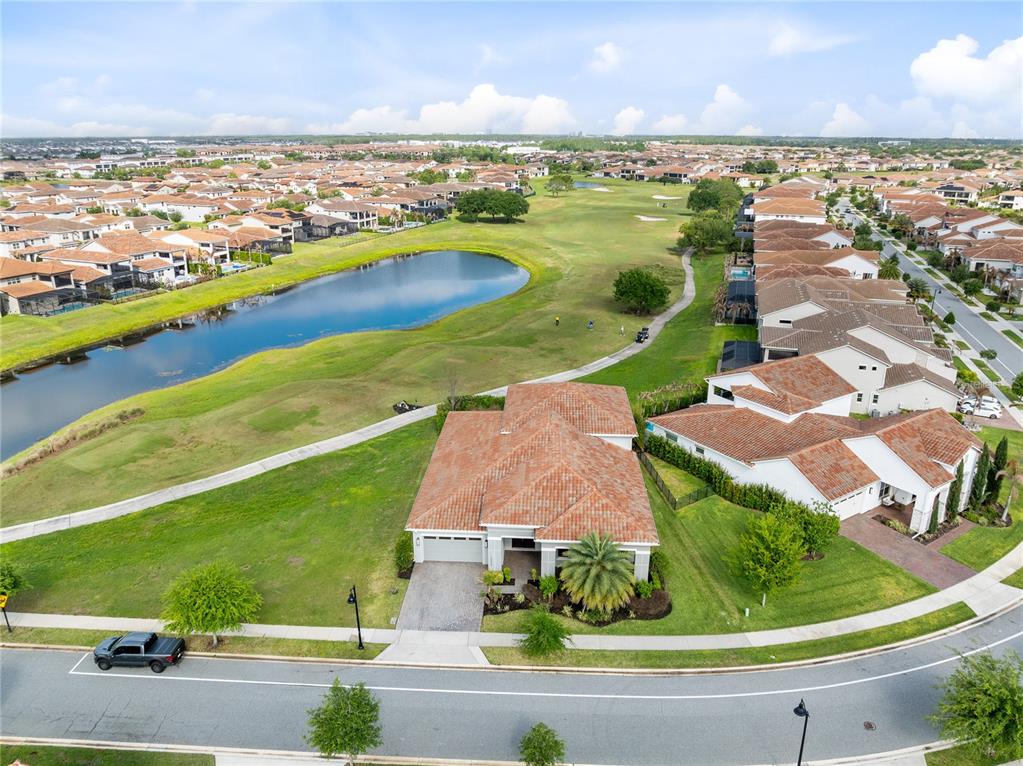 An aerial view shows a single-story house with a tile roof beside a golf course — 13370 ALDERLEY DRIVE, ORLANDO, FL