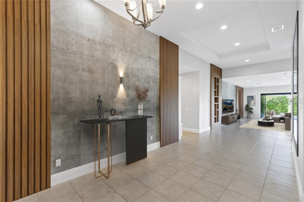 A modern entryway features a concrete-textured accent wall, vertical wood slats, and a console table — 13370 ALDERLEY DRIVE, ORLANDO, FL