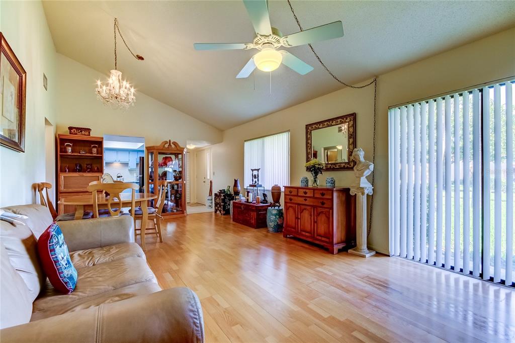 A living and dining area with hardwood floors, a ceiling fan, and a chandelier — 9537 86TH AVENUE UNIT 9537, SEMINOLE, FL