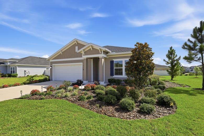 A single-story suburban house with a two-car garage and a landscaped front yard — 2110 RAGLAN CIRCLE, ORMOND BEACH, FL