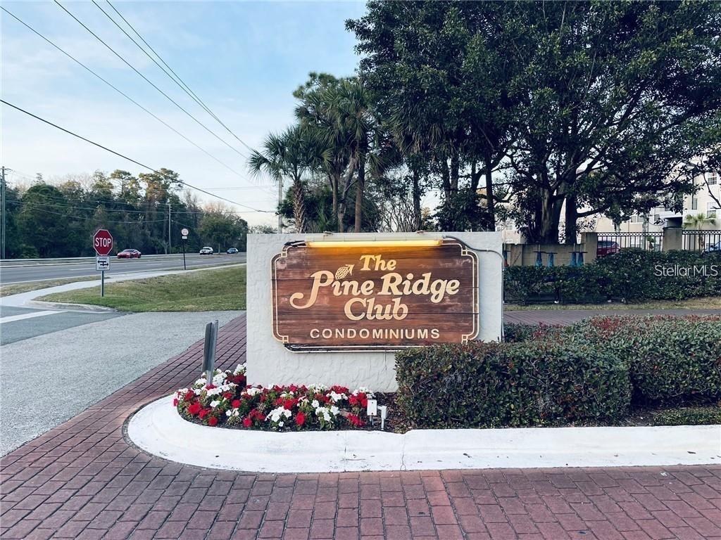 A sign for The Pine Ridge Club Condominiums stands near a road and landscaping — 1723 PINE RIDGE ROAD UNIT 23, SANFORD, FL