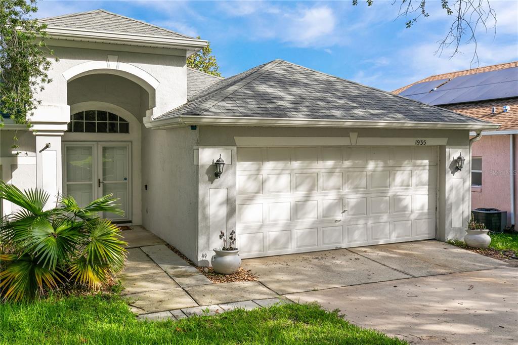A single-story house with a white stucco exterior, a two-car garage, and a front entryway — 1935 WESTPOINTE CIRCLE, ORLANDO, FL