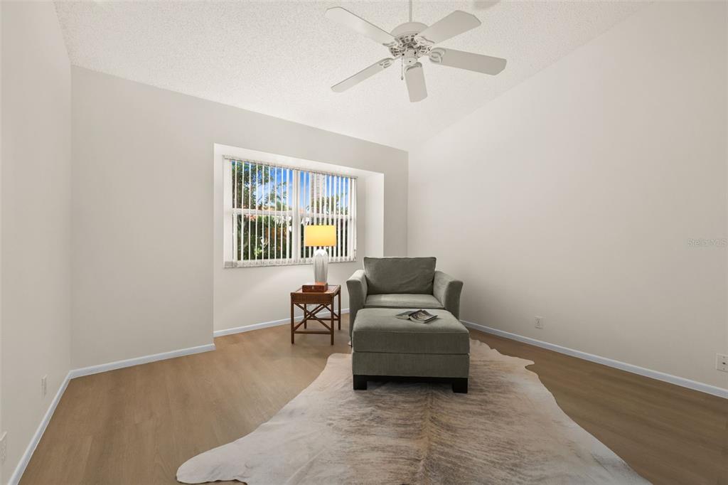 A room with light-colored walls, wood-look flooring, a ceiling fan, and a chair with ottoman — 4825 TAMARACK TRAIL, VENICE, FL