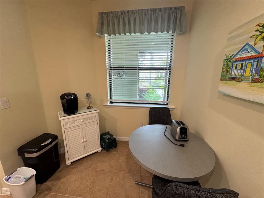 A small dining area features a round table, a white cabinet, and a window — 20096 PEZZANA DRIVE, VENICE, FL