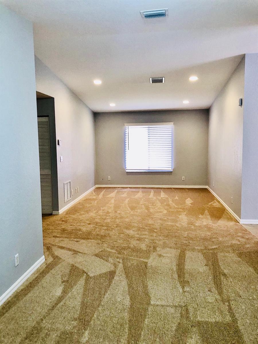 An empty room with beige carpet, light gray walls, recessed lighting, and a single window — 4801 SE Graham Drive, Stuart FL 34997, STUART, FL